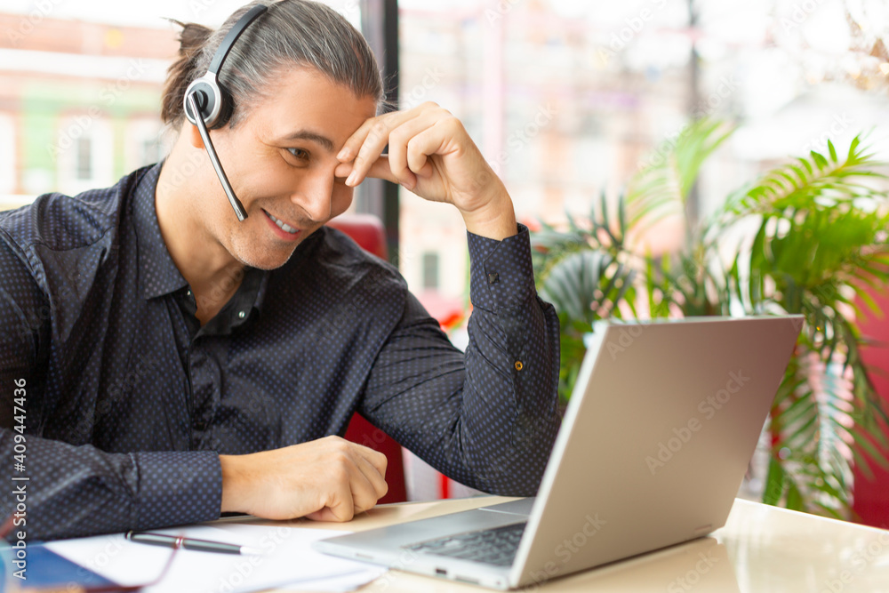 Smiling middle aged man during online video call. Smiling middle aged man during online video call.