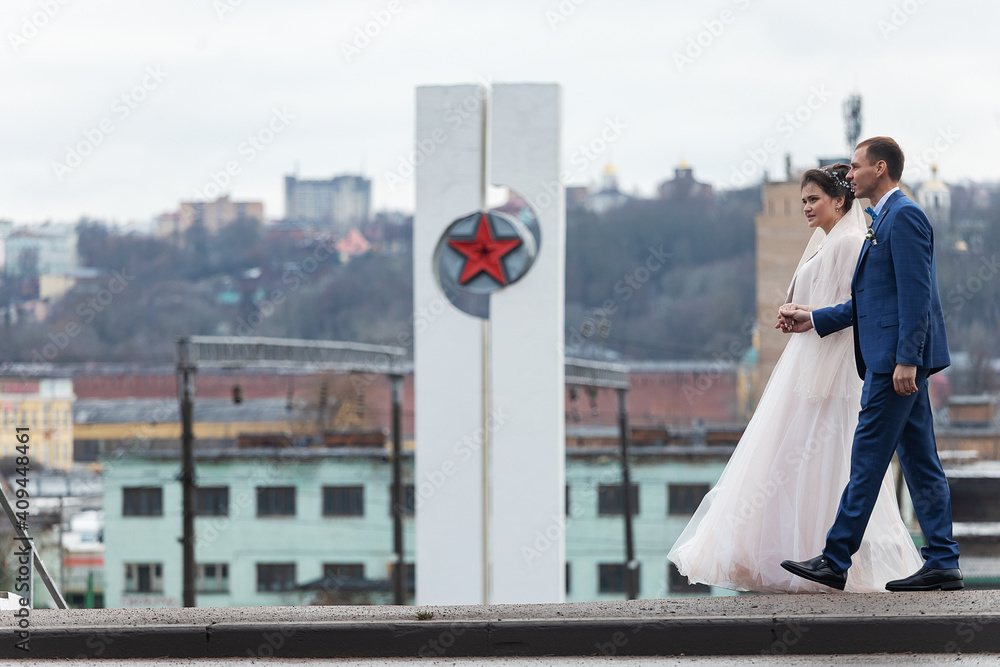 the bride and groom on the background of a church, religious lovers, a wedding walk in winter, a man and a woman gently kiss and smile hugs