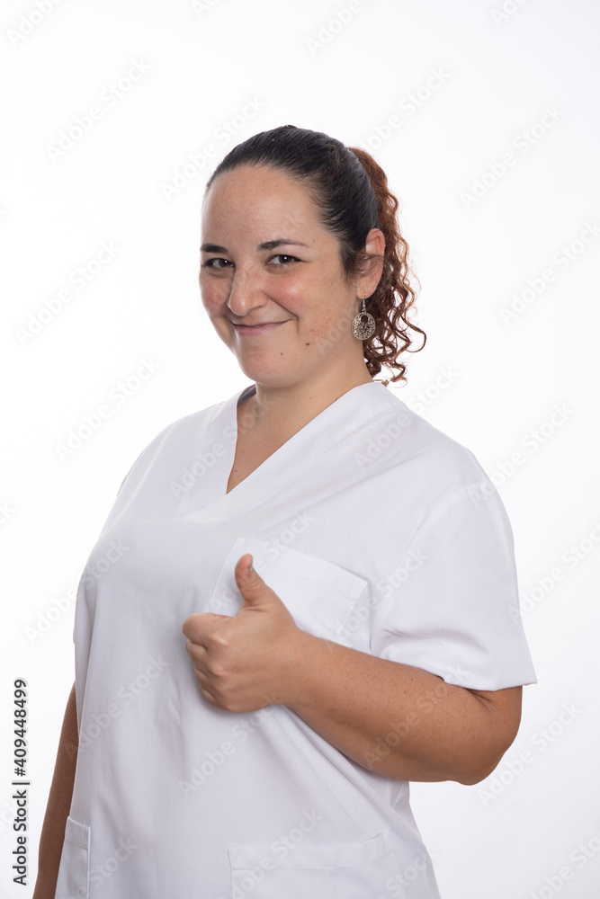 Woman wearing white scrub doing a thumbs up smiling Woman wearing white scrub doing a thumbs up smiling