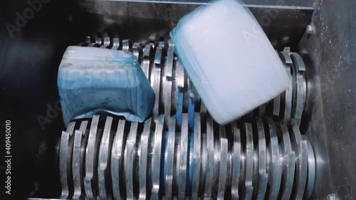 The plastic shredder recycles plastic cans. Close-up of cutters