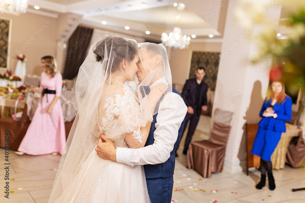 the bride and groom kiss in a restaurant, the happiness of the newlyweds at the wedding ceremony, a romantic kiss