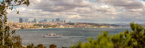 Panoramic View of a ferry crossing the Bosphorus Straits, with a city of Istanbul, Turkey in the background