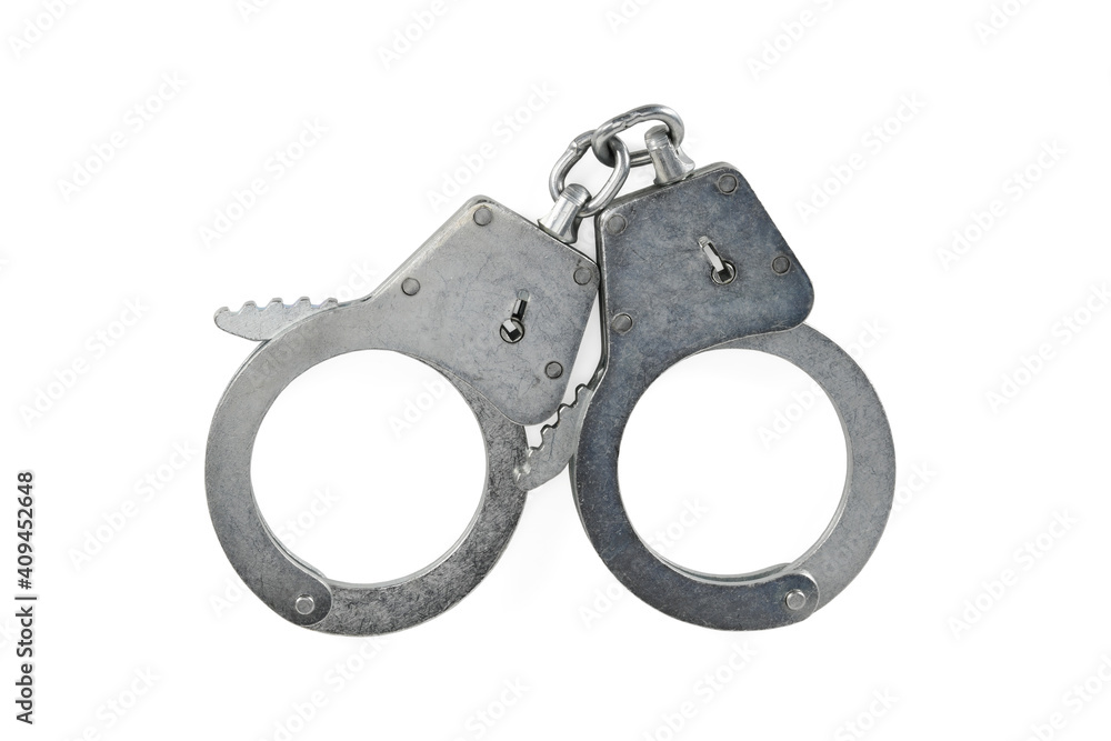 Police handcuffs isolated on white background with light shadows. Pair of real metal handcuffs macro close-up high resolution. Police handcuffs isolated on white background with light shadows. Pair of real metal handcuffs macro close-up high resolution.