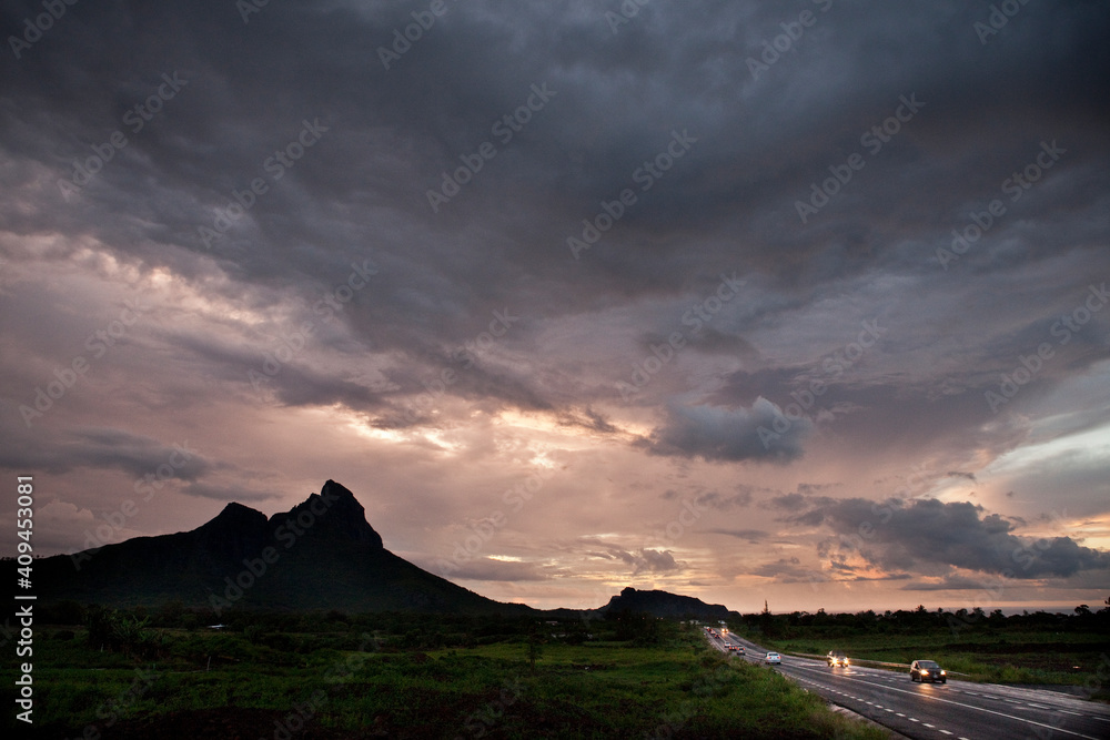 Naklejka premium Sunset sky and mountain silhouette in Mauritius.