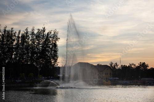 View cityscape Udonthani city and landscape fountain spray in pond evening time for thai people travel visit and rest relax at Nong Prajak Recreation Centre Public Park in Udon Thani, Thailand photo