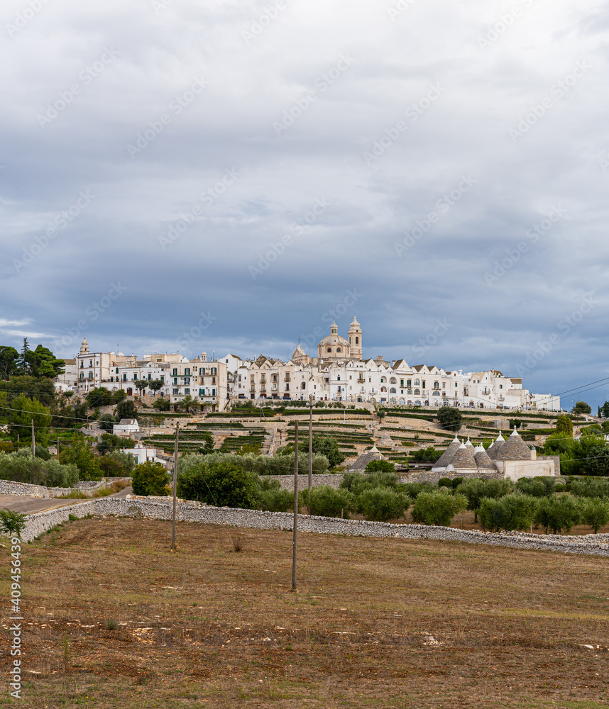 View of the skyline of Locortondo in Puglia from an olive tree field
