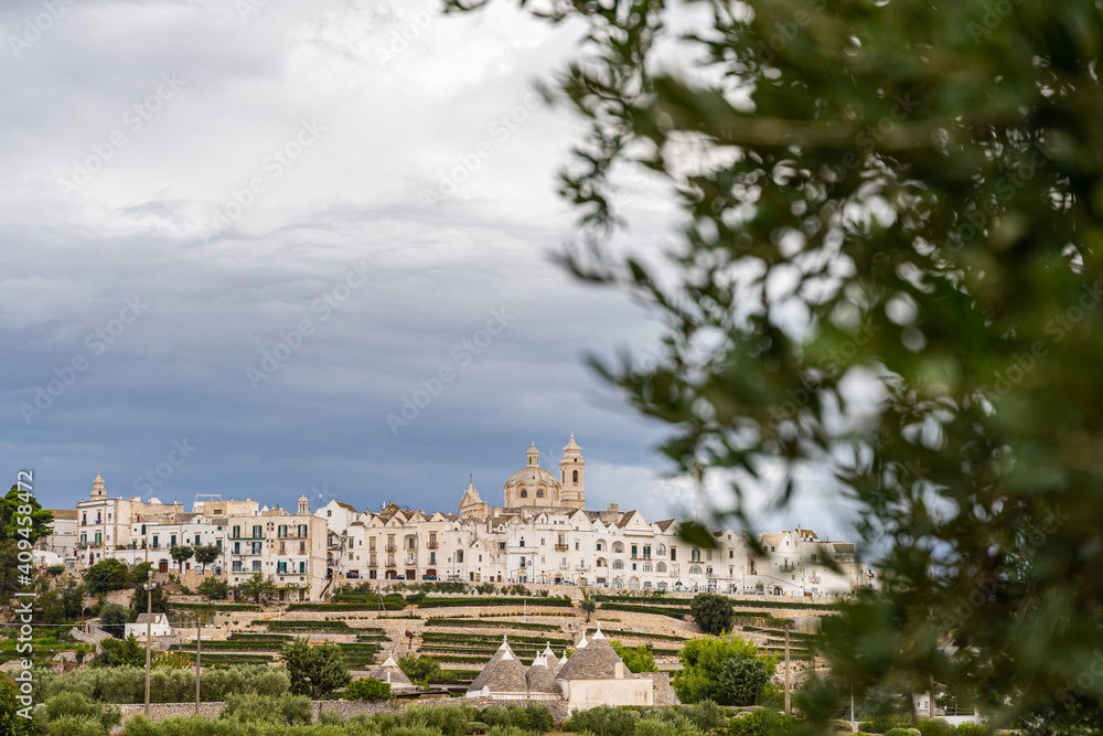 View of the skyline of Locortondo in Puglia from an olive tree field