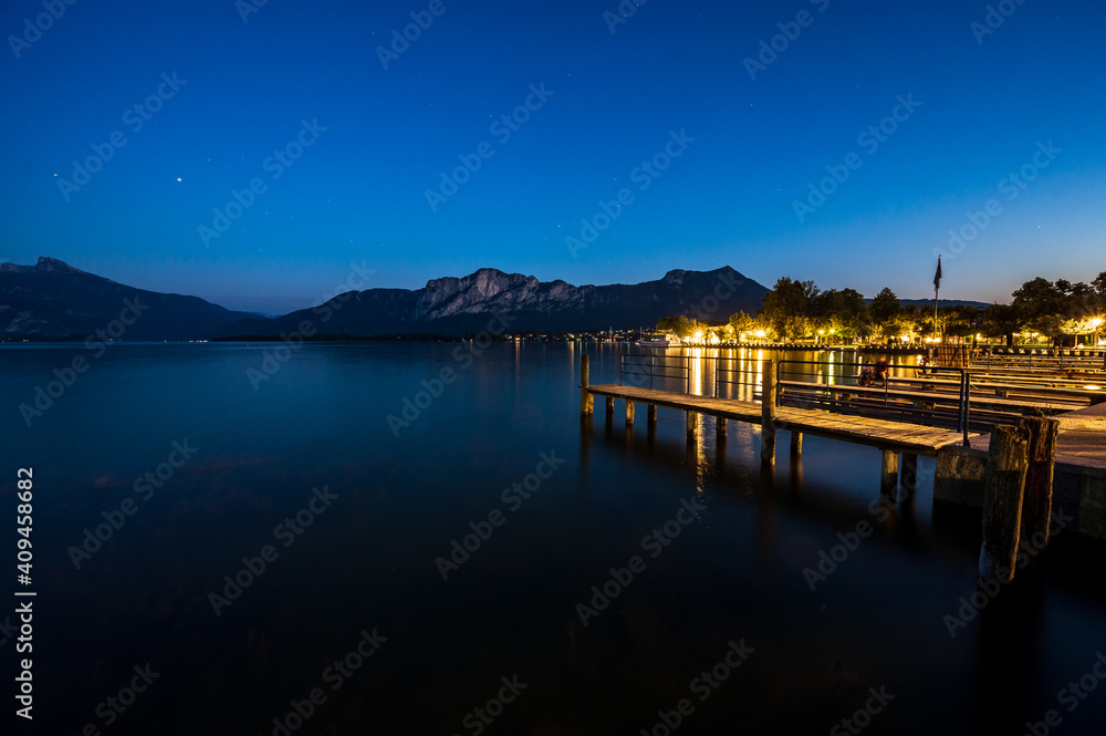 Wooden jetties at lake Mondsee near Salzburg during blue hour