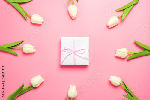 Spring flowers white tulips on pink background with gift box. Mother's day or women's day composition.