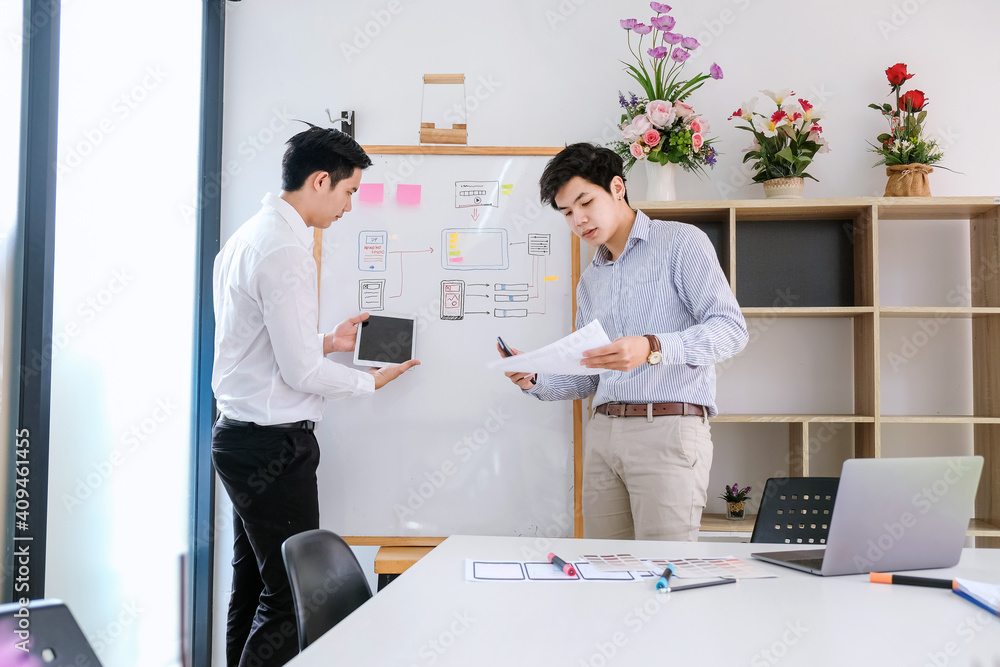 Two asian designer man share ideas mobile phone app development at the office. Two asian designer man share ideas mobile phone app development at the office.