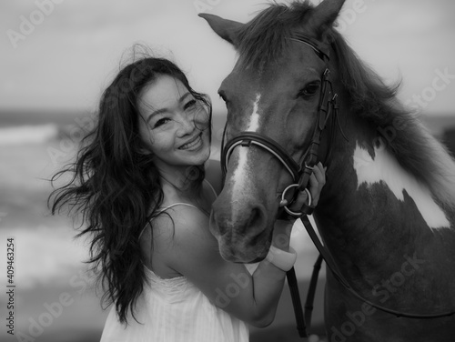 Monochrome. Portrait of smiling woman and horse. Woman hugging horse. Romantic concept. Love to animals. Black-white photo. Nature concept. Bali photo