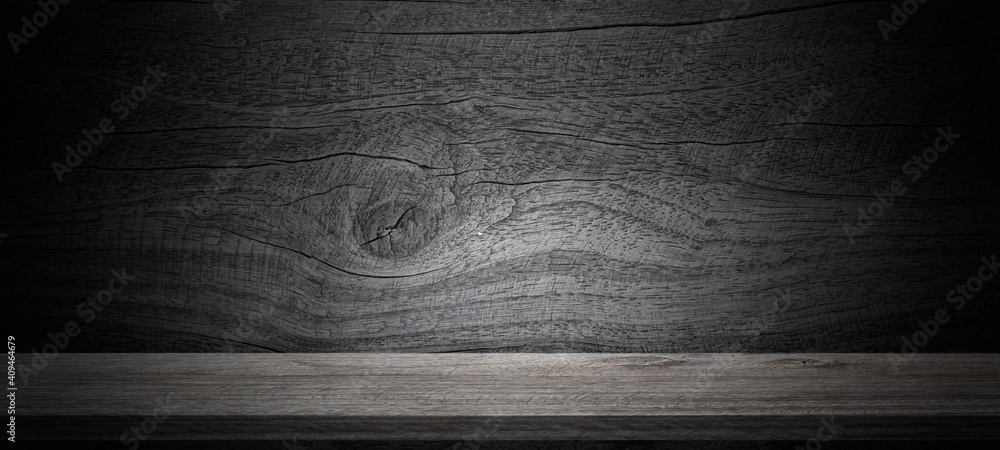 Naklejka premium Empty wooden table on wall dark background,perspective wooden floor shelf table,used as a studio background wall to display your products.