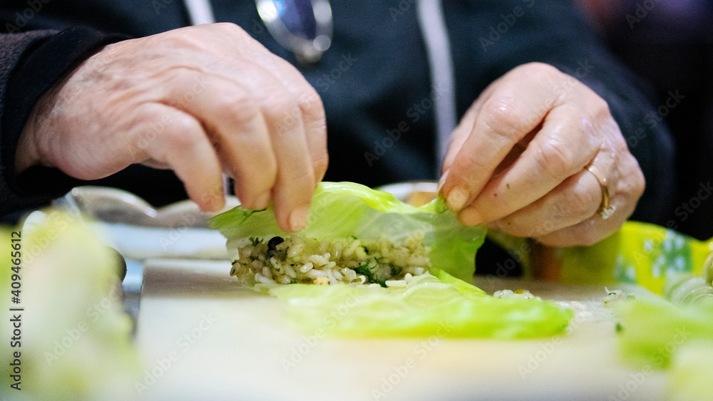 woman's hands making stuffed cabbage woman's hands making stuffed cabbage
