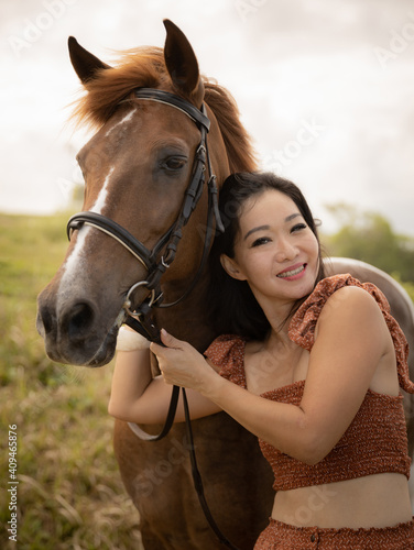 Portrait of happy woman and brown horse. Asian woman hugging horse. Romantic concept. Positive emotions. Human and animals relationship. Nature concept. Bali © Olga