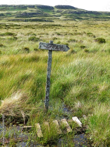 Old wooden footpath signpost in peat bog on Isle of Mull photo