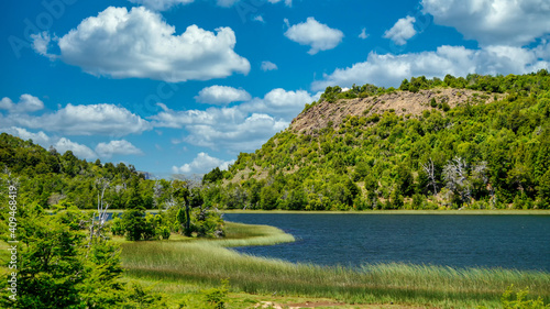 Landscape of lake Rosales surrounded by a forest and a few hills in San Martin de los Andes, Neuquen, Argentina. Taken on a warm summer morning   