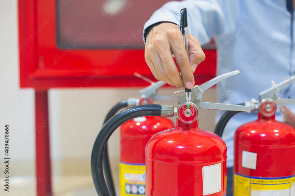 Expert engineers inspect fire extinguishers to be ready for use. Expert engineers inspect fire extinguishers to be ready for use.