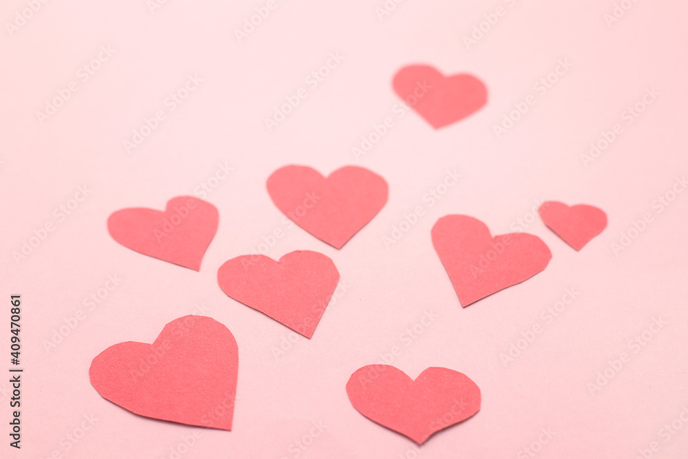 Concept for Valentine's Day February 14th. Red Valentine's Day hearts cards on pink background.