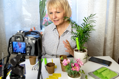 Social media concept. Woman sits at home using a camera and recording an online gardening course