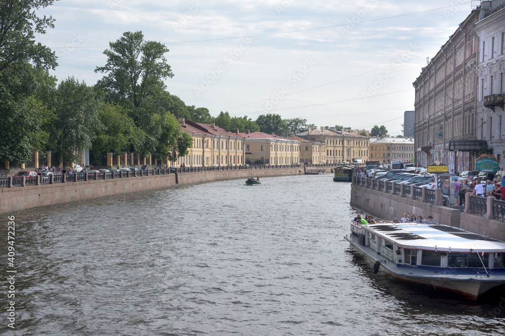 Obraz premium Tourists moving along the canals on foot and on ships