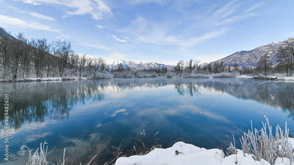 Paesaggio con vista sul lago, in inverno, con la neve sulle montagne
