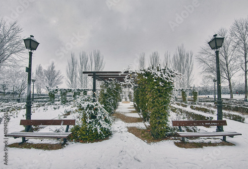 A park in a heavy snowfall in the afternoon