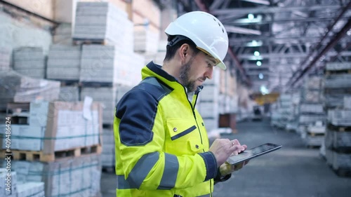 Follow footage of employees male warehouse worker engineer in hard hat working. walking through logistics center warehouse factory construction site logistics architect businessman man builder indoors