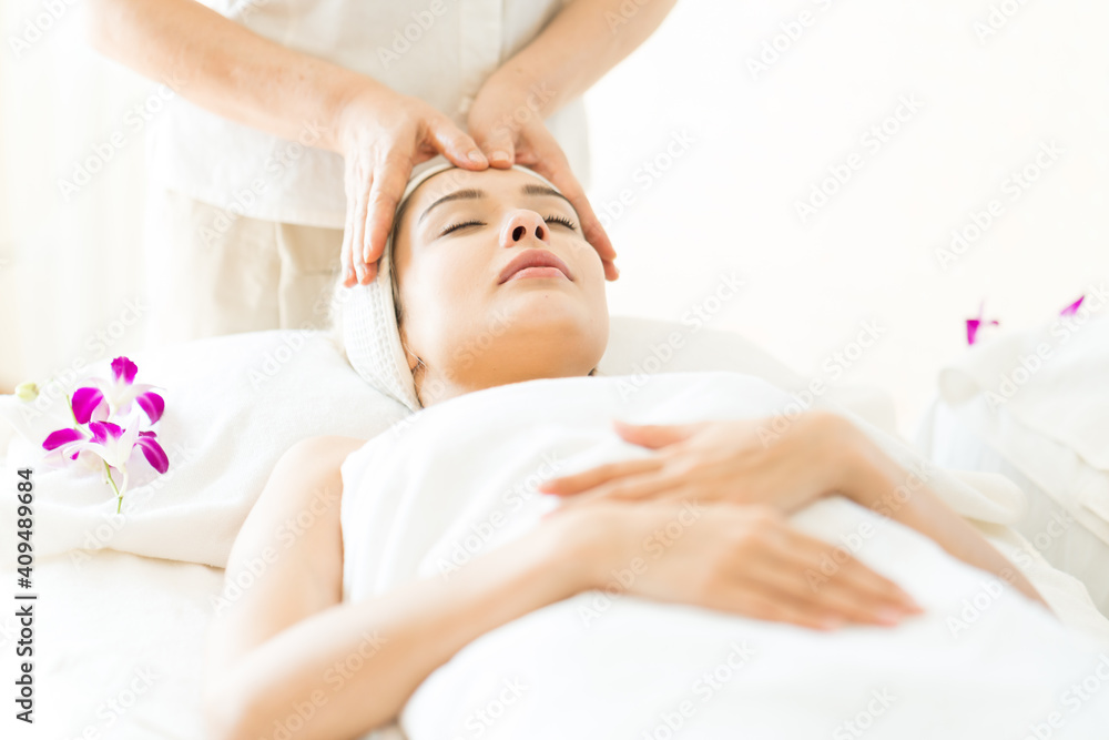 young beautiful woman in spa salon. Attractive woman enjoying a head massage.