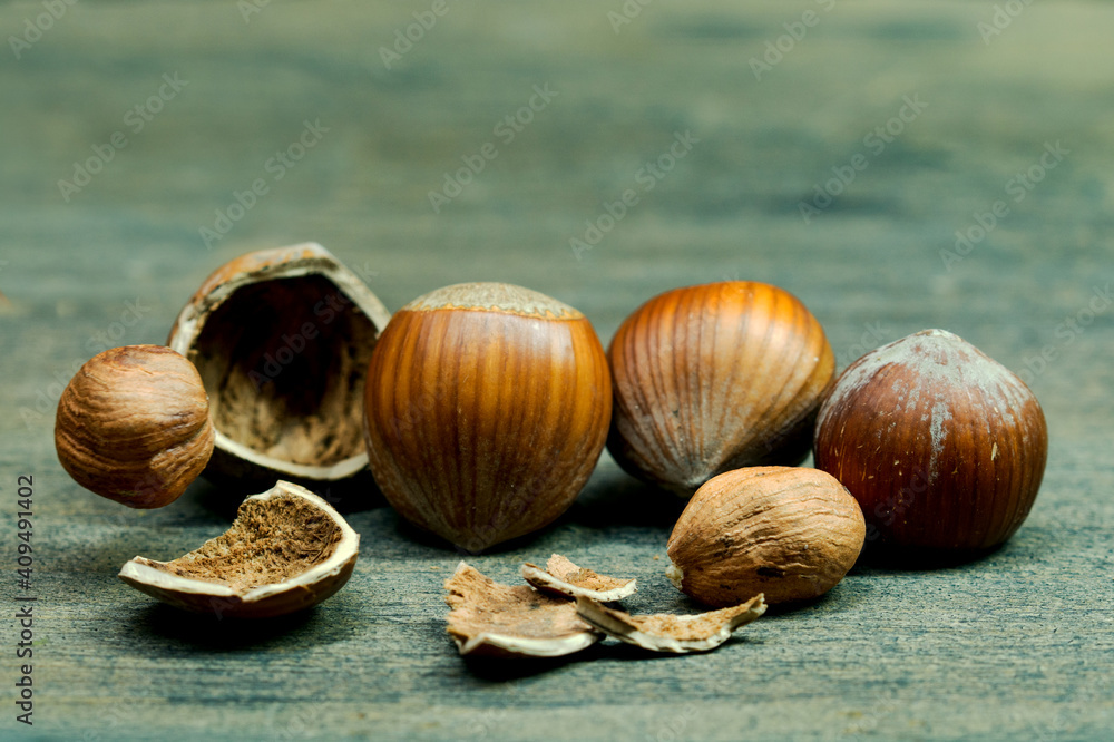 Tossed Hazelnut food nuts Background, falling on wooden table. hazelnut breaking into pieces after falling on a structural table Tossed Hazelnut food nuts Background, falling on wooden table. hazelnut breaking into pieces after falling on a structural table