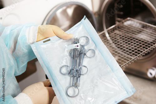 A dental clinic employee puts sterilization instruments in a dry firing cabinet. The concept of sterility and hygiene in the clinic. Unrecognizable person. Only hand.