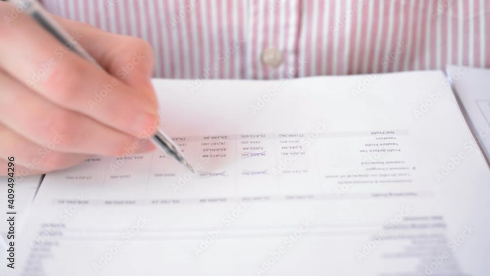 Auditor's hands are checking financial report closely Auditor's hands are checking financial report closely