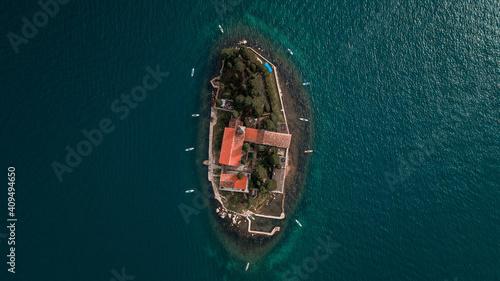 Amazing Aerial view with SUP stand up paddle boards around Our Lady of the Rock island and Church in Perast on shore of Boka Kotor bay (Boka Kotorska), Montenegro, Europe.