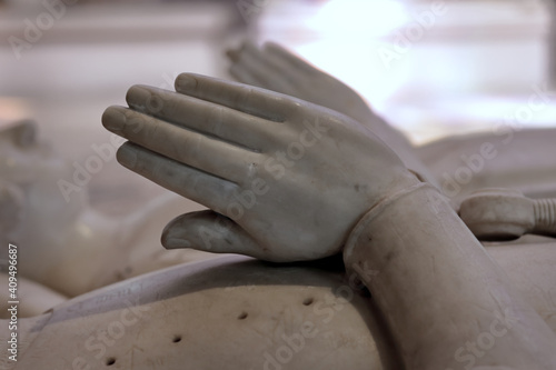 Folded hands on a statue of an old tomb, concept of death