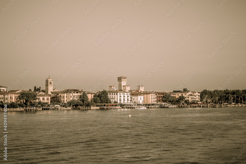 Fototapeta premium The pier and promenade of Sirmione on Lake Garda. Autumn evening. Lombardy, Italy