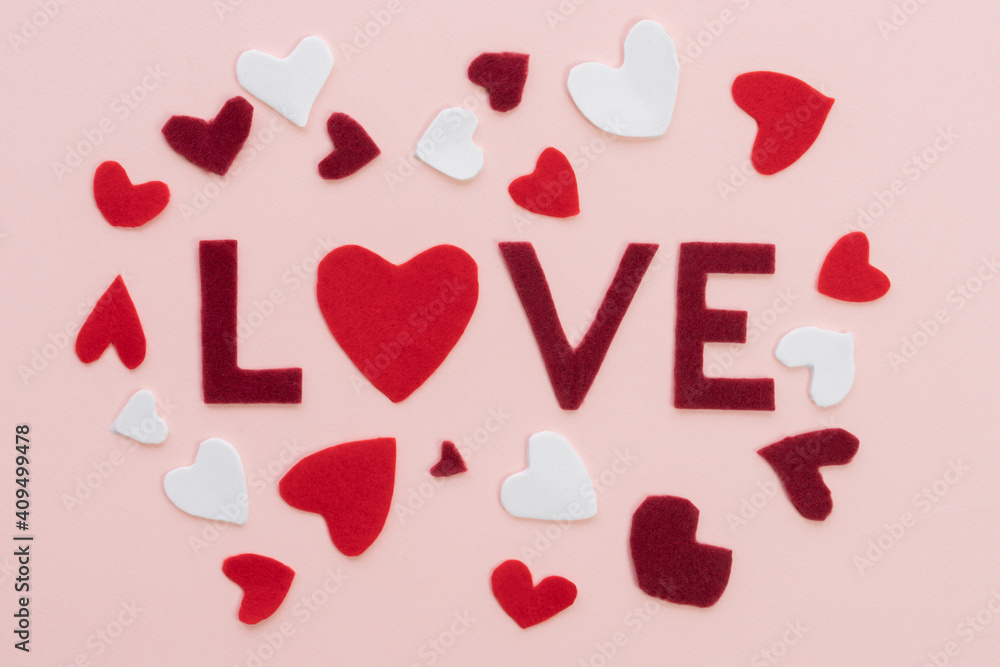 Composition for Valentine's Day February 14th Soft pink cute background frame word love, red and white hearts cut out of felt. Greeting card flat lay top view 2021 Love concept.