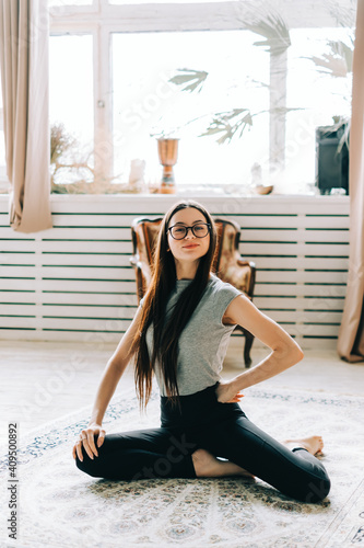 Portrait of cheerful brunette fitness woman doing yoga indoors at home. Staying fit and healthy