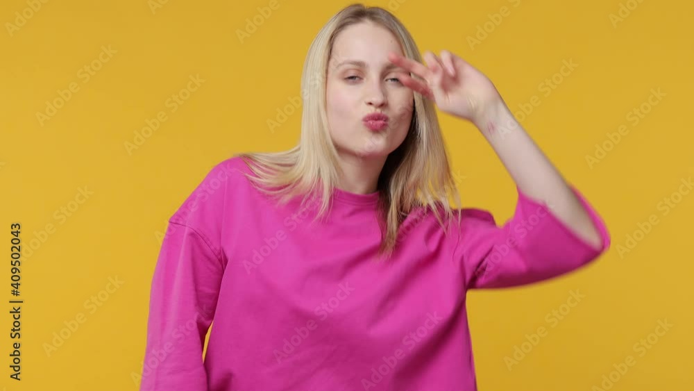 Cheerful funny young woman 20s years old in casual pink t-shirt posing isolated on yellow color background studio. People lifestyle concept. Dancing clenching fists waving hands showing victory sign Cheerful funny young woman 20s years old in casual pink t-shirt posing isolated on yellow color background studio. People lifestyle concept. Dancing clenching fists waving hands showing victory sign