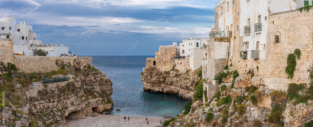 The beach of Polignano a Mare with its steep cliffs of the old town The beach of Polignano a Mare with its steep cliffs of the old town