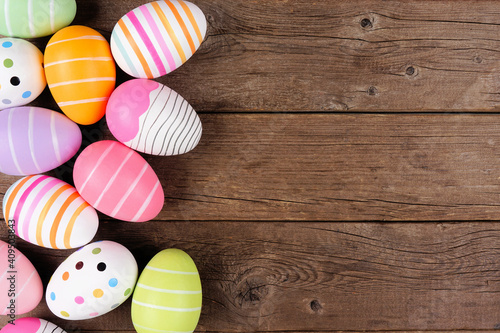 Colorful Easter Egg side border. Overhead view against a rustic wood background. Copy space.