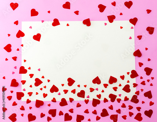 Confetti hearts on pink background with postcard and copy space. Red decorative heart. There was plenty of room for text in the apartment. The concept of Valentine's day
