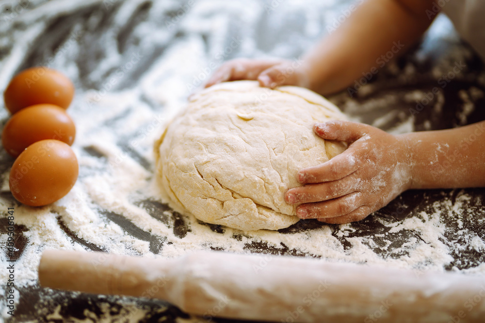 Children hands kneading dough on wooden table. Easter baking preparation. Cookies for Christmas. Children hands kneading dough on wooden table. Easter baking preparation. Cookies for Christmas.