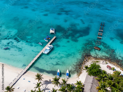 Aerial drone view of the paradise beach with old and new pier, boats, yacht, palm trees and blue water of Caribbean Sea, Saona island, Dominican Republic