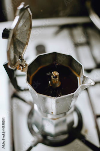 coffee is brewed in a steel italian moka on a gas stove