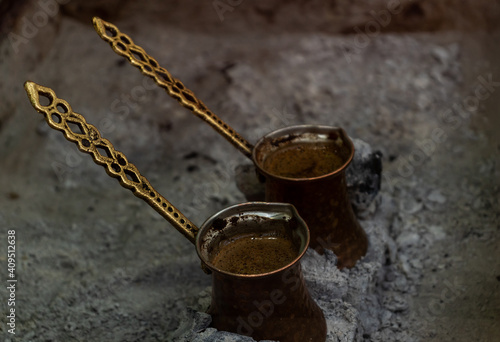 Cooking Tradition Turkish Coffee in Metal Coffee Pot Ibrik on Hot Coals. Espresso in Turkey.