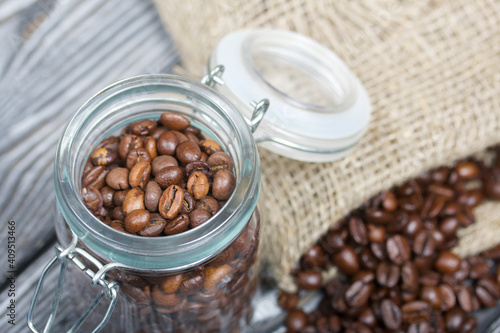 Coffee beans. Poured into a drag bag jar and linen bag. Close-up shot.