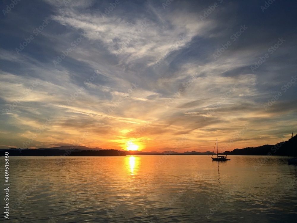 Sundown over a beautiful bay with a sailboat anchored out in the Gulf Islands, British Columbia, Canada