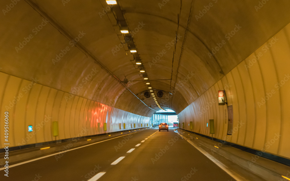Drive through an empty highway tunnel before exciting the light