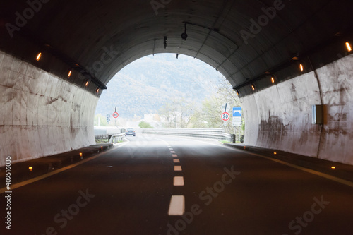 Drive through an empty highway tunnel before exciting the light