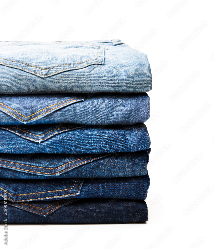 Lot of various used women jeans stacked in a pile isolated on white Lot of various used women jeans stacked in a pile isolated on white
