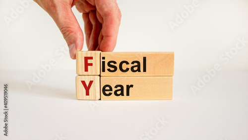 Fiscal year symbol. Concept words 'fiscal year' on wooden cubes and blocks on a beautiful white background. Businessman hand. Business and fiscal year concept.